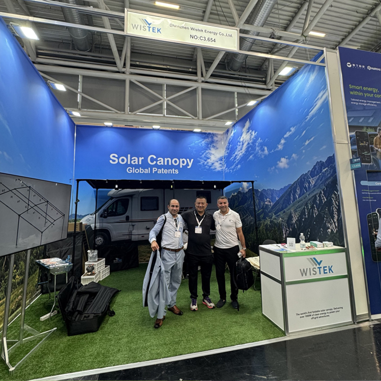 The Wistek team smiling and posing for a group photo with global clients at the expo booth, showcasing green energy partnership.